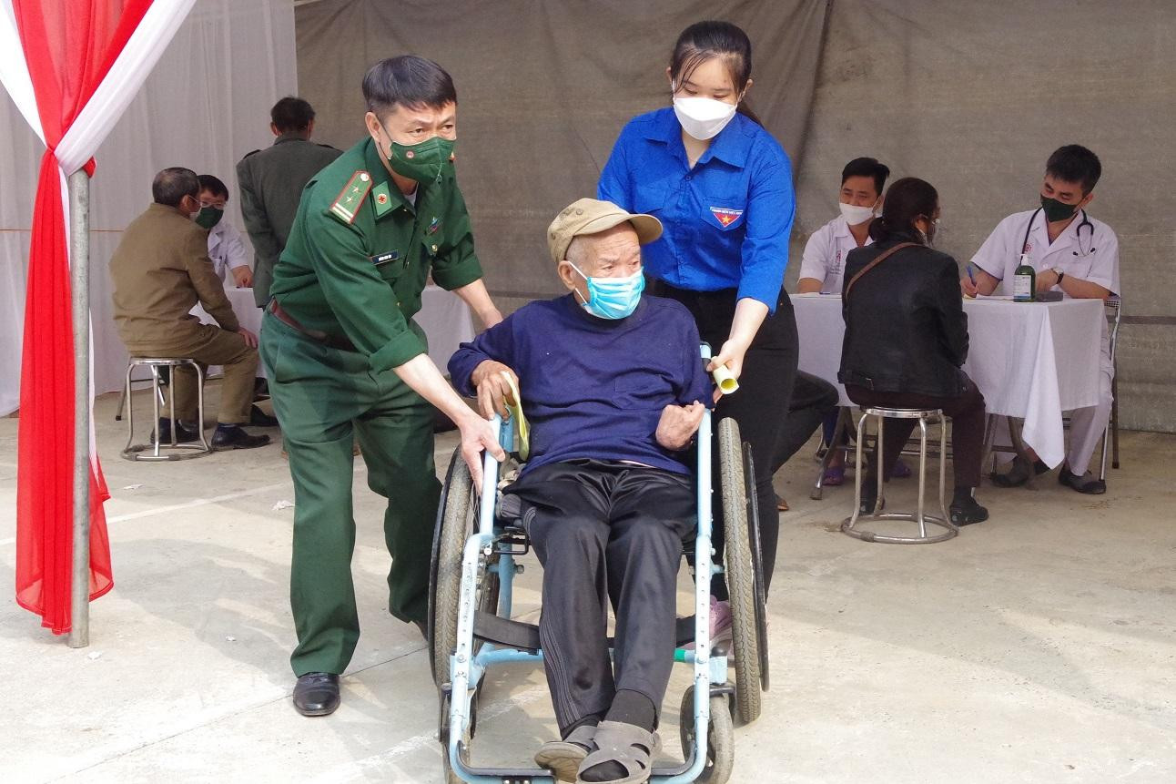 Quân y Bộ đội Biên phòng và ĐVTN địa phương hỗ trợ người dân đến khám, chữa bệnh.