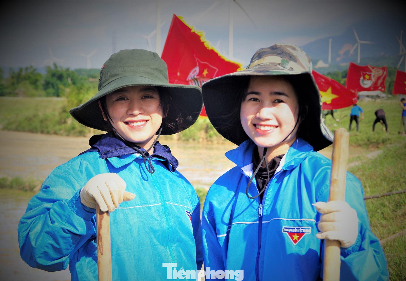 Niềm vui của hai nữ Tri thức trẻ tình nguyện Đoàn KT-QP 337 khi giúp đỡ bà con trên những cánh đồng ở xã Hướng Linh. Ảnh: Võ Đông