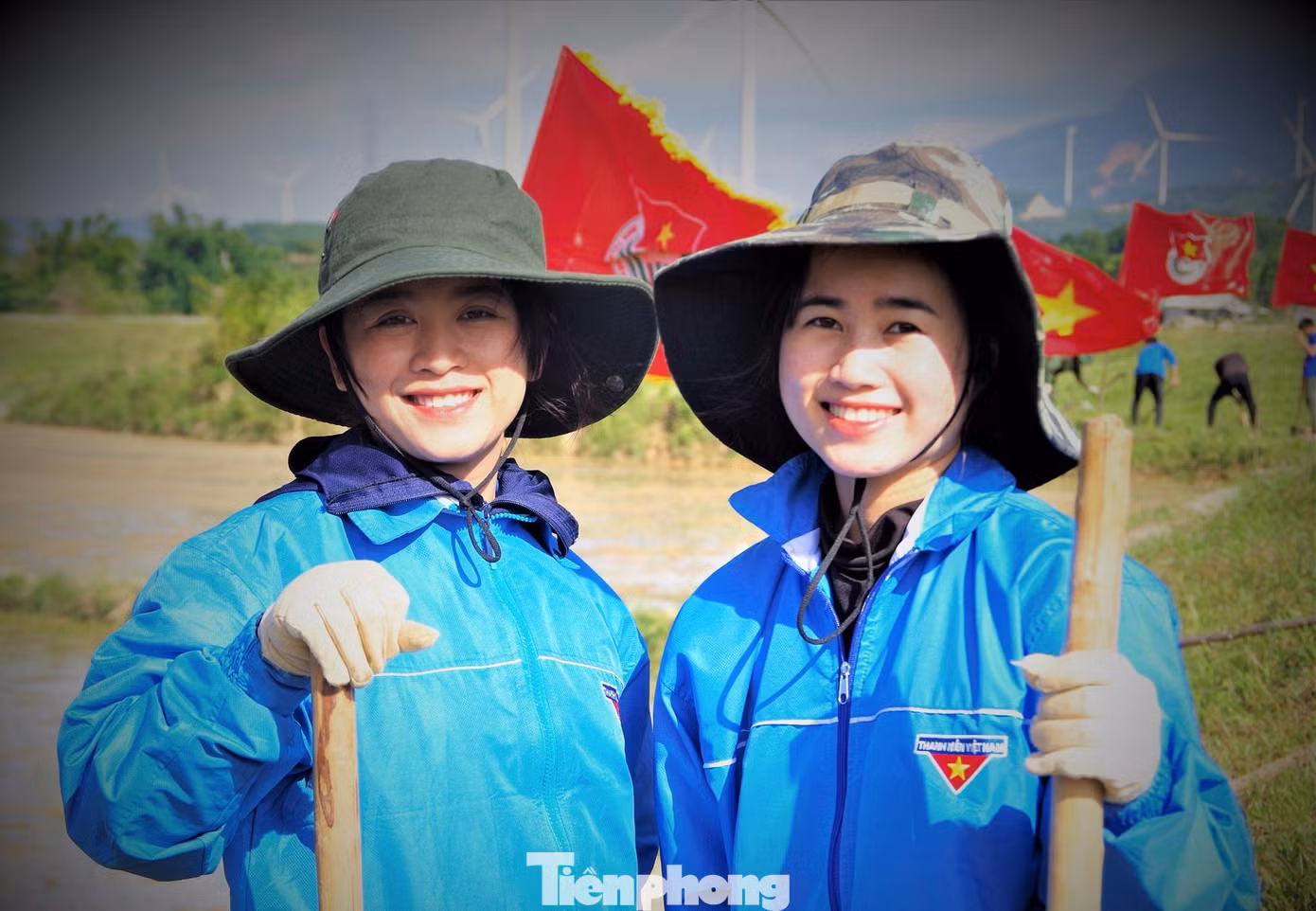 Niềm vui của hai nữ Tri thức trẻ tình nguyện Đoàn KT-QP 337 khi giúp đỡ bà con trên những cánh đồng ở xã Hướng Linh. Ảnh: Võ Đông