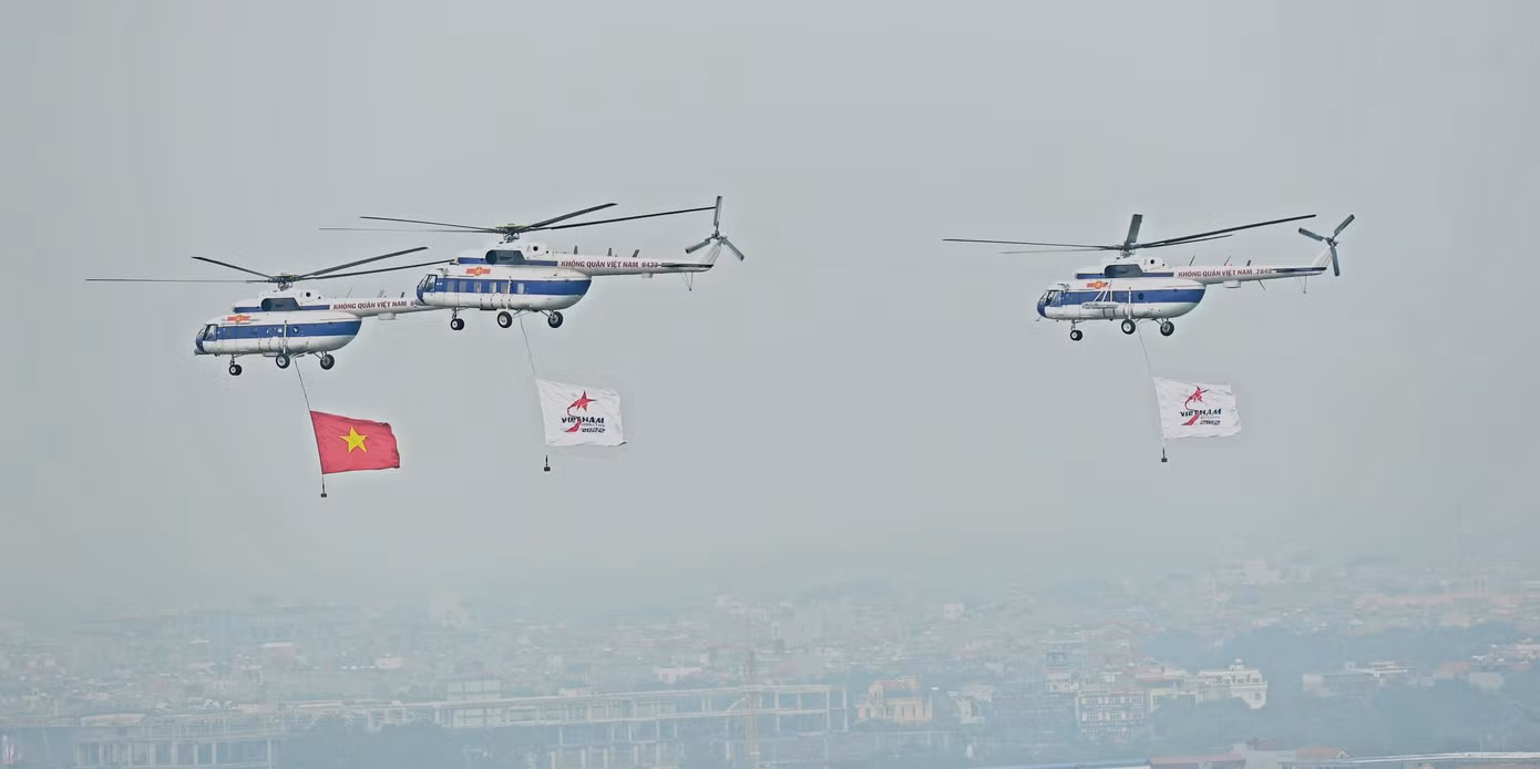 Trực thăng vũ trang treo cờ Việt Nam và cờ triển lãm bay biểu diễn. Ảnh: Trọng Tài