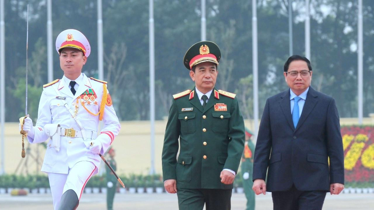 Bộ trưởng Bộ Quốc phòng Phan Văn Giang đón và tháp tùng Thủ tướng Phạm Minh Chính tới dự, chủ trì lễ khai mạc triển lãm, sáng 8/12. Ảnh: Mạnh Thắng