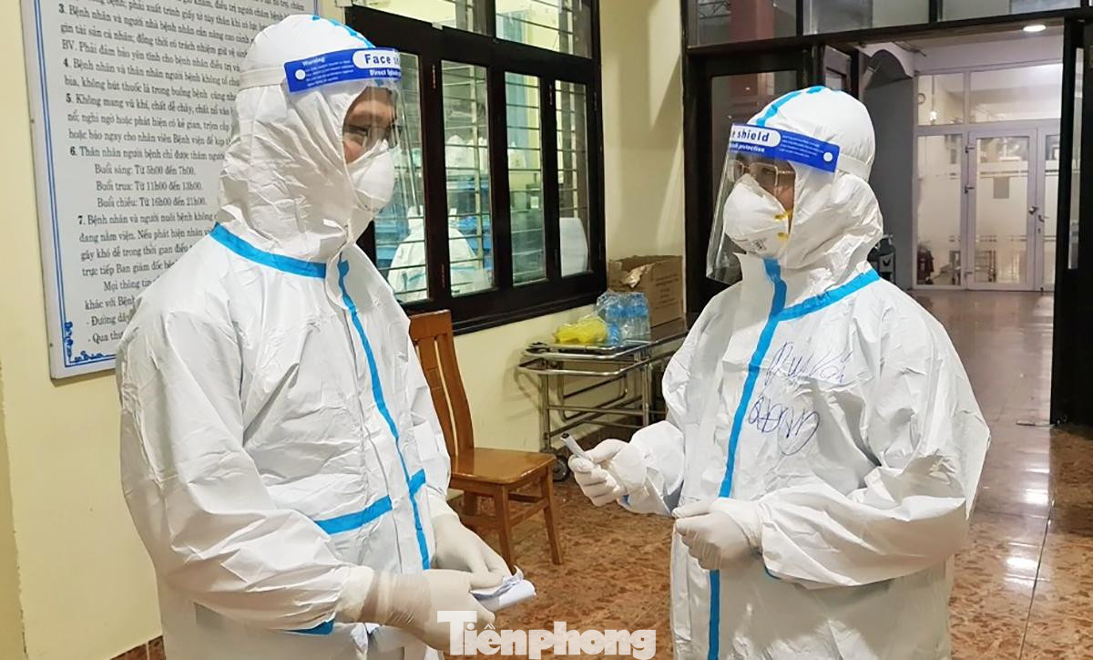 Thiếu tá Duy Văn (bên phải) tác nghiệp tại khu điều trị bệnh nhân COVID-19 nặng ở Bệnh viện Quân y 175, TPHCM