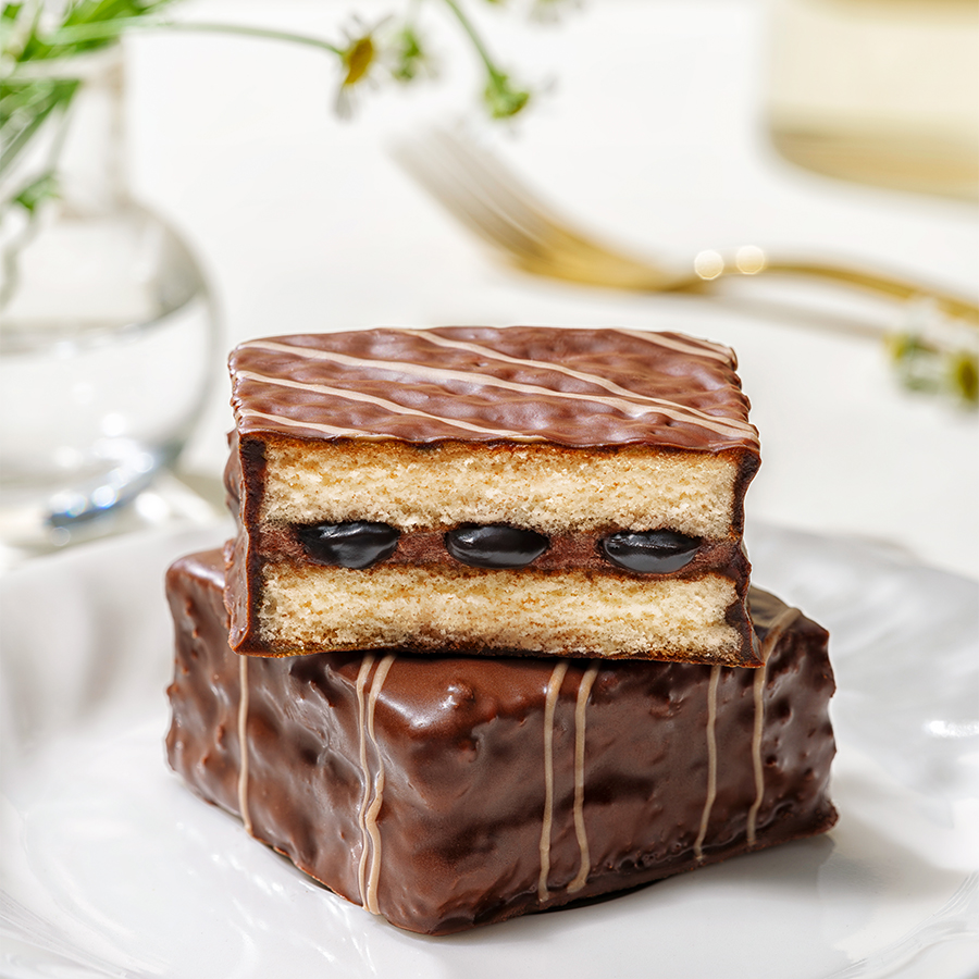 Chiếc bánh Opera đan xen hoàn hảo giữa bánh bông lan, nhân kem và lớp phủ socola Chiếc bánh Opera đan xen hoàn hảo giữa bánh bông lan, nhân kem và lớp phủ socola