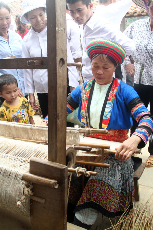 Phụ nữ H'mông dệt sợi lanh ngay tại chợ. Hình ảnh này thu hút nhiều du khách