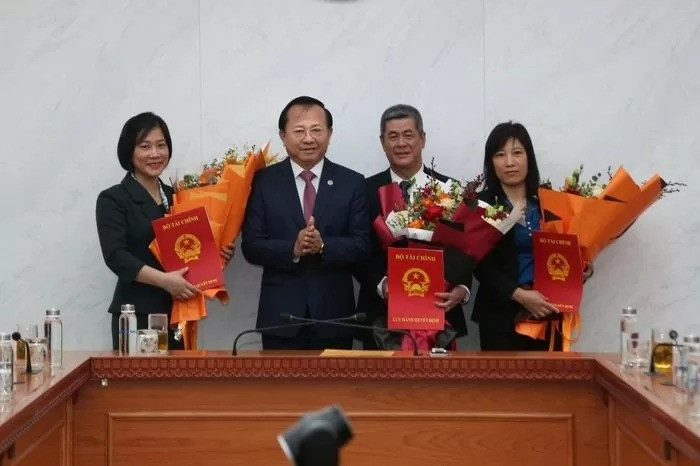 Thứ trưởng Lê Tấn Cận trao các quyết định và tặng hoa cho 3 tân lãnh đạo Vụ Ngân sách Nhà nước, Viện Chiến lược và Chính sách tài chính. Ảnh: Thời báo Tài chính