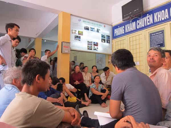 Bệnh nhân ngồi chờ trước cửa phòng khám cột sống Bệnh viện Việt Đức vào 14h45 ngày 1-8 Ảnh: Nguyễn Hoài