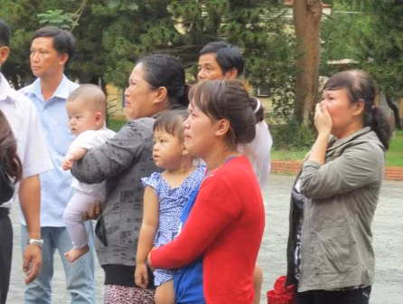 Hai đứa con cùng với mẹ và người thân nhìn cha lần cuối