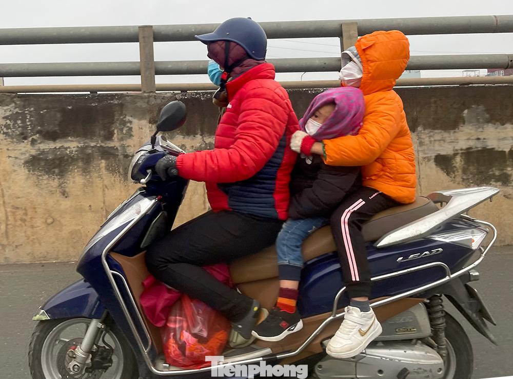 Người mẹ chở các con dưới trời rét, mưa phùn