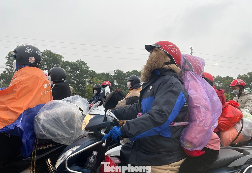 Nhiều người dân chở theo đồ đạc chen chân giữa trời mưa rét.