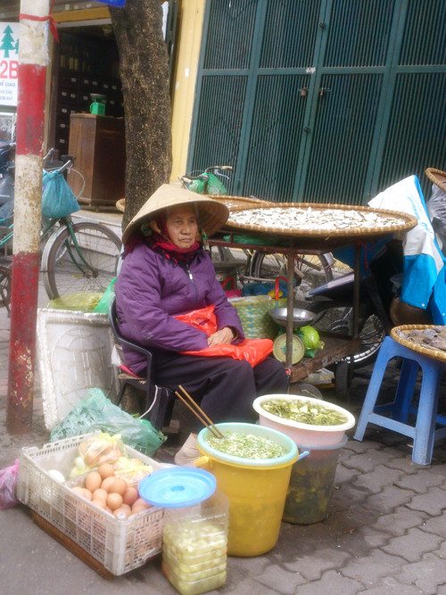 Dù đã ở tuổi ngoài tám mươi nhưng cụ bà này hằng ngày vẫn ngồi bán dưa cà, trứng ở góc phố Thể Giao, phường Nguyễn Du, quận Hai Bà Trưng, Hà Nội. Cụ cho biết, gia đình rất đông con, cháu. Ở nhà một chỗ không thích nên cụ vẫn hằng ngày ra đây ngồi bán rau dưa kiếm thêm đồng tiền. Ảnh: Tuấn Nguyễn. 
