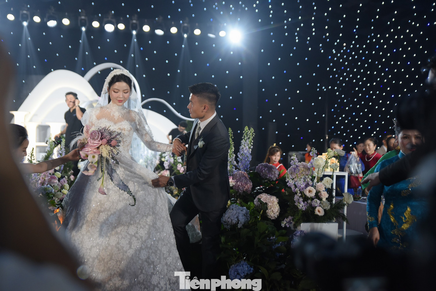Quang Hải nâng váy cho Chu Thanh Huyền khi cô bước xuống từ sân khấu. Cử chỉ quan tâm, ngọt ngào của chú rể nhận được sự tán dương của những người chứng kiến.