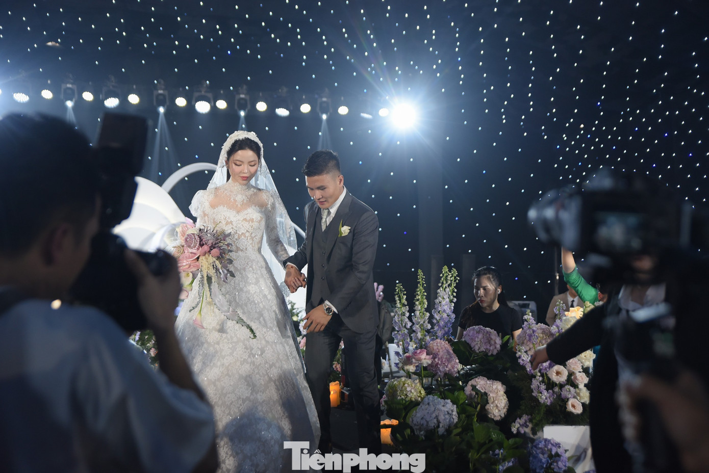 Quang Hải nâng váy cho Chu Thanh Huyền khi cô bước xuống từ sân khấu. Cử chỉ quan tâm, ngọt ngào của chú rể nhận được sự tán dương của những người chứng kiến.