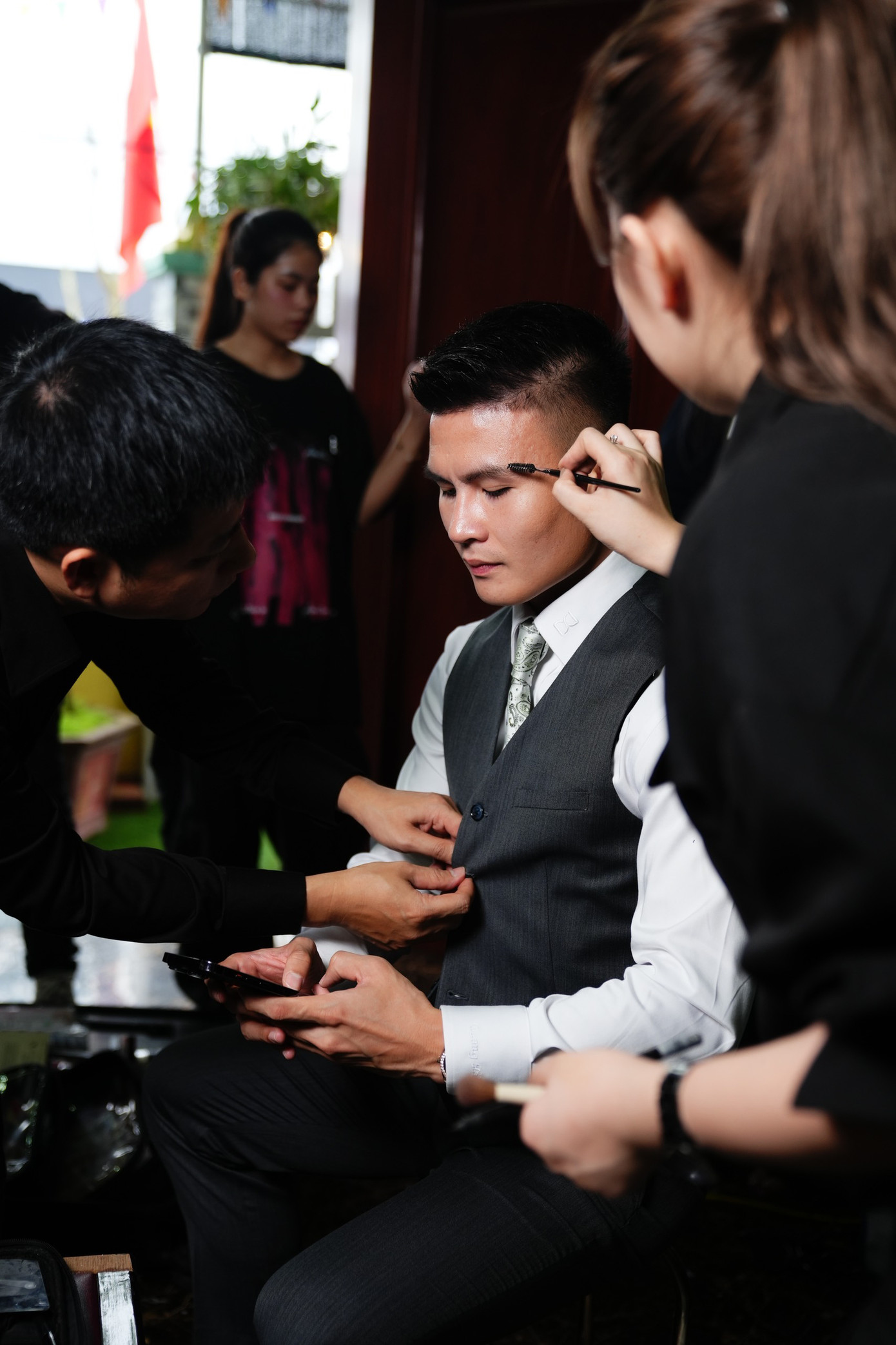 Trước giờ đón dâu, chú rể được ê-kíp hỗ trợ trang điểm nhẹ và làm tóc đơn giản chuẩn bị cho thời khắc trọng đại.