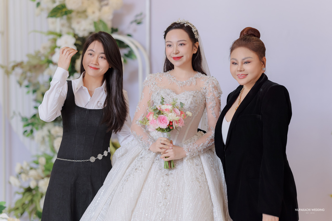 Lê Giang và NTK Jennie Vũ chụp ảnh kỷ niệm cùng cô dâu. Là đàn chị thân thiết, Lê Giang không quản ngại đường xa, từ TPHCM ra Hải Dương dự đám cưới. Trong khi đó, Jennie Vũ chính là người thiết kế hai chiếc váy cưới trị giá 600 triệu đồng cho Kim Oanh diện trong ngày trọng đại.