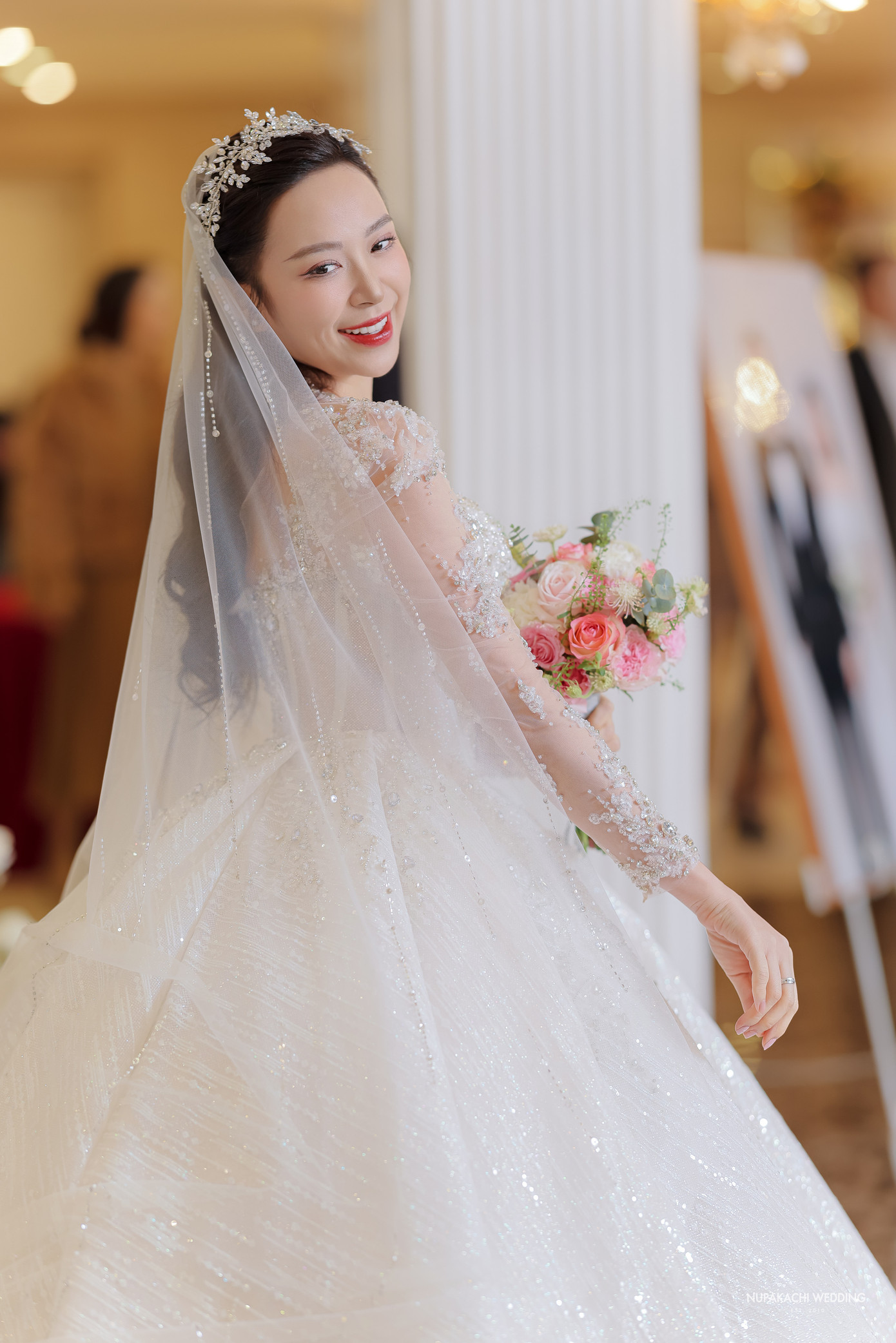 Váy cưới của Kim Oanh được thiết kế riêng cho cô mang tên Swan Fairy - Vũ điệu thiên nga. Chiếc váy được may bằng chất liệu duchess satin kết hợp đính lông vũ và đá.