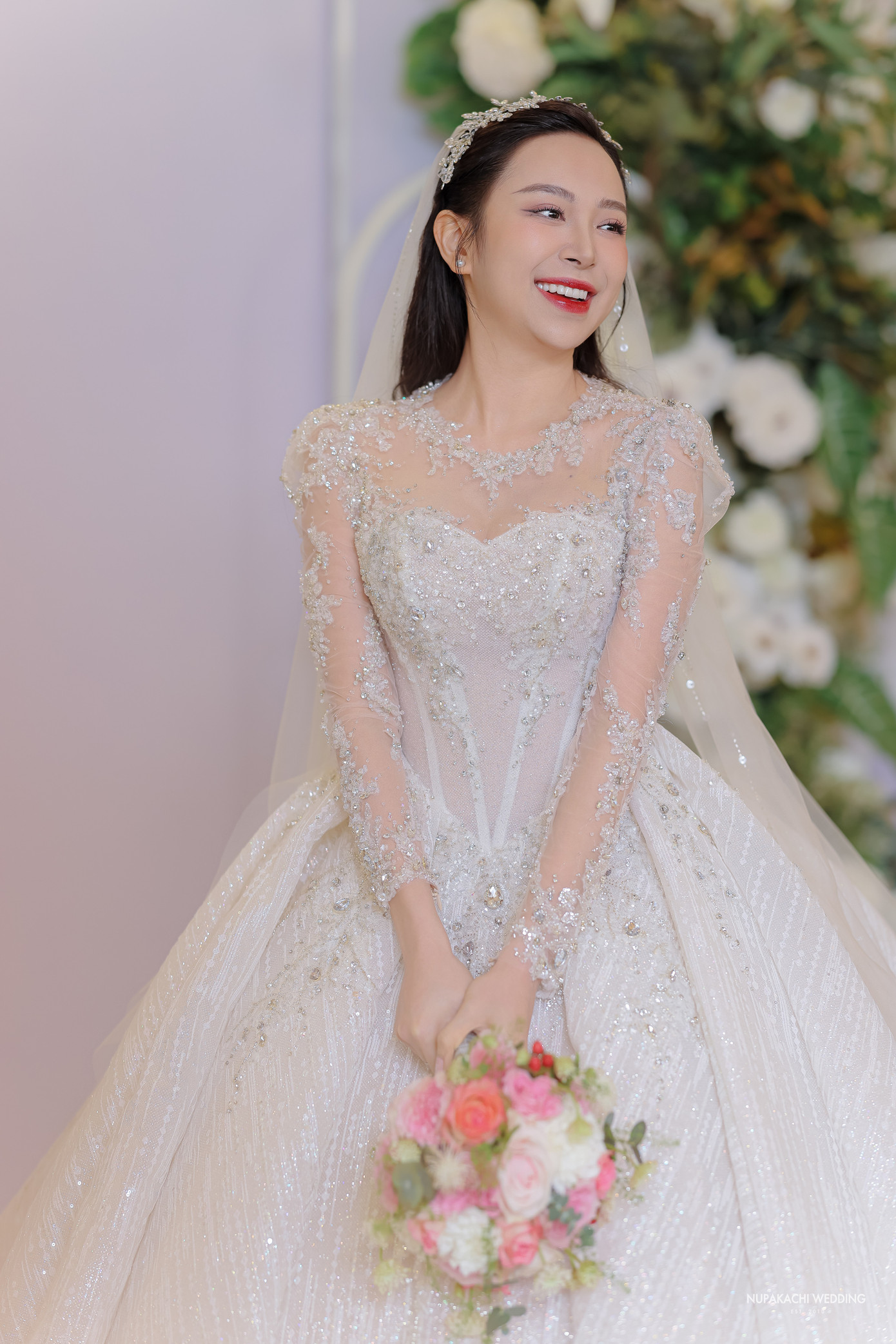 Váy cưới của Kim Oanh được thiết kế riêng cho cô mang tên Swan Fairy - Vũ điệu thiên nga. Chiếc váy được may bằng chất liệu duchess satin kết hợp đính lông vũ và đá.