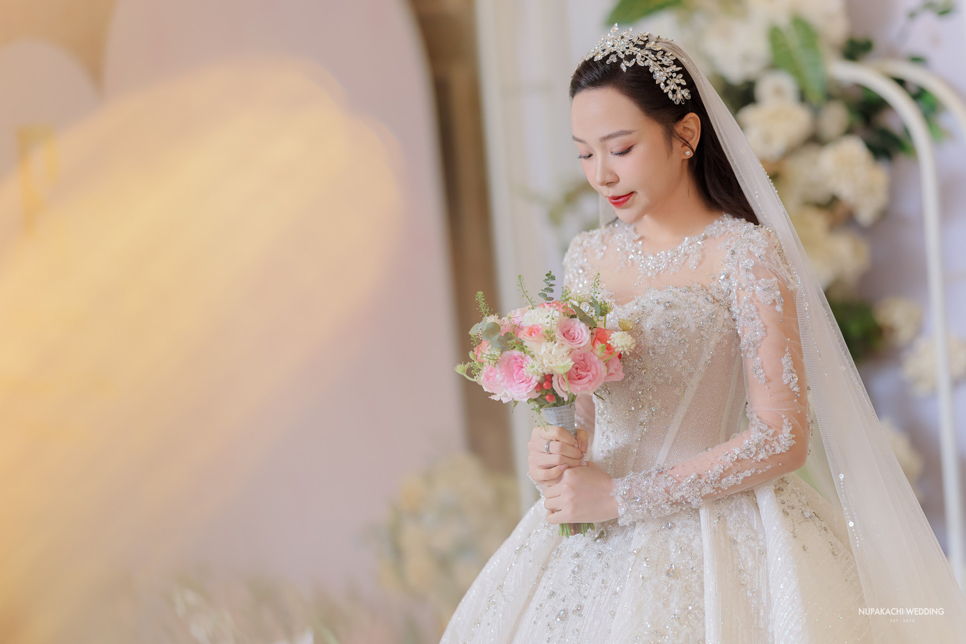 Váy cưới của Kim Oanh được thiết kế riêng cho cô mang tên Swan Fairy - Vũ điệu thiên nga. Chiếc váy được may bằng chất liệu duchess satin kết hợp đính lông vũ và đá.