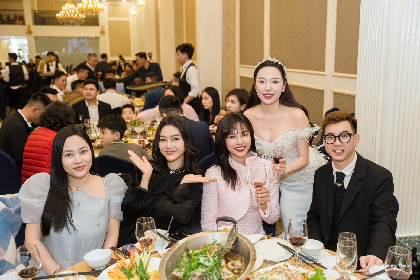 Khi đón khách, nữ diễn viên diện đầm cúp ngực với phần điểm nhấn đuôi cá voan bồng đẹp mắt và đính hơn 15 loại đá như swarovski, topaz, chaton, crystal… Chiếc váy được ê-kíp lên ý tưởng và thiết kế trong hơn 1.000 giờ đồng hồ.