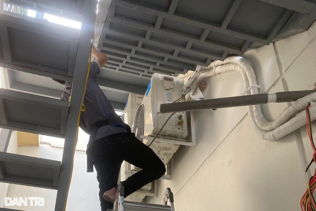 Thợ sửa máy lạnh thu nhập tiền triệu mỗi ngày nhưng cũng tiềm ẩn nhiều nguy hiểm khi phải làm việc trên cao giữa trời nắng nóng (Ảnh: Xuân Trường).