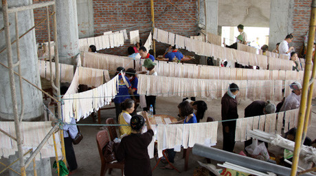 Các băng giấy in kinh được phết nước thơm, phơi khô, cuộn chặt, bỏ lọ để yểm tầng cao của tháp