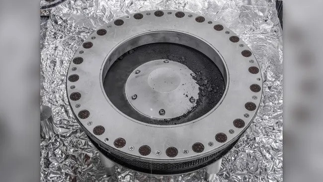 Hình ảnh bên ngoài của bộ thu mẫu OSIRIS-REx. Vật liệu mẫu từ tiểu hành tinh Bennu có thể được nhìn thấy ở giữa bên phải. (Ảnh: NASA/Erika Blumenfeld & Joseph Aebersold) Hình ảnh bên ngoài của bộ thu mẫu OSIRIS-REx. Vật liệu mẫu từ tiểu hành tinh Bennu có thể được nhìn thấy ở giữa bên phải. (Ảnh: NASA/Erika Blumenfeld & Joseph Aebersold)