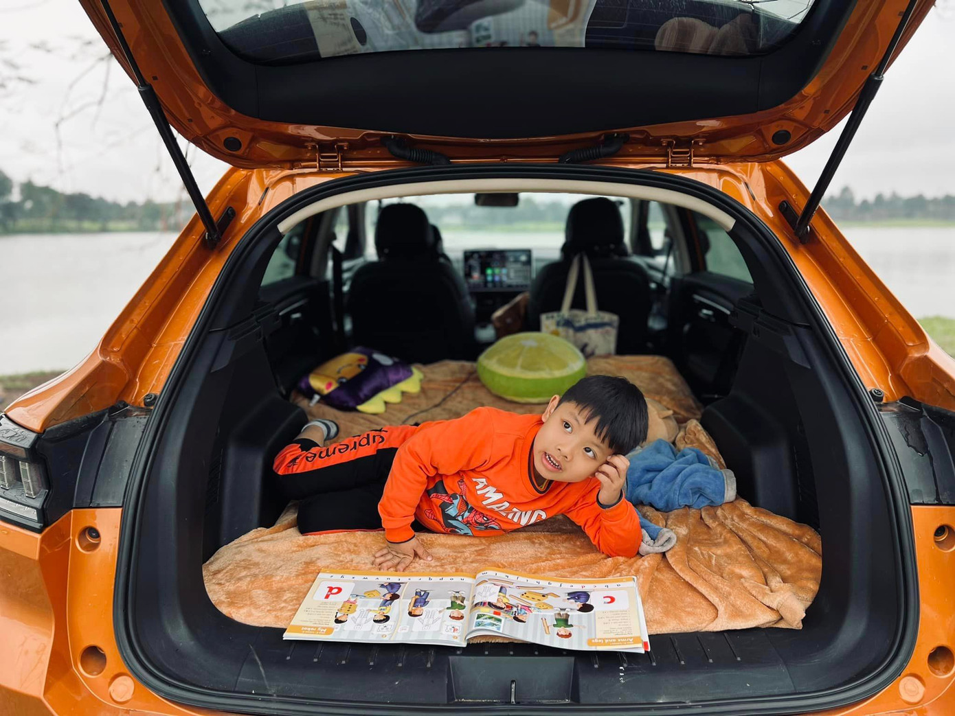 Hàng ghế sau gập phẳng được đã trở thành “chiếc giường di động” của cậu bé (Nguồn ảnh: Facebook Trần Danh Nhân).