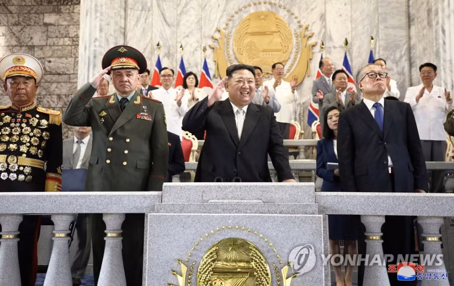 Nhà lãnh đạo Triều Tiên Kim Jong Un (giữa) đứng cạnh Bộ trưởng Quốc phòng Nga Sergei Shoigu (trái) và Phó Chủ tịch Quốc hội Trung Quốc Lý Hồng Trung trên khán đài trung tâm để chứng kiến lễ duyệt binh ngày 27/7. (Ảnh: KCNA)
