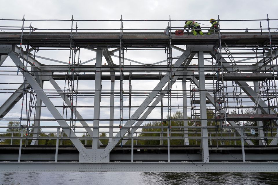 Các công nhân đang làm việc trên cây cầu bắc qua sông Raumo ở Tornio, Phần Lan, ngày 31/5. (Ảnh: Reuters)