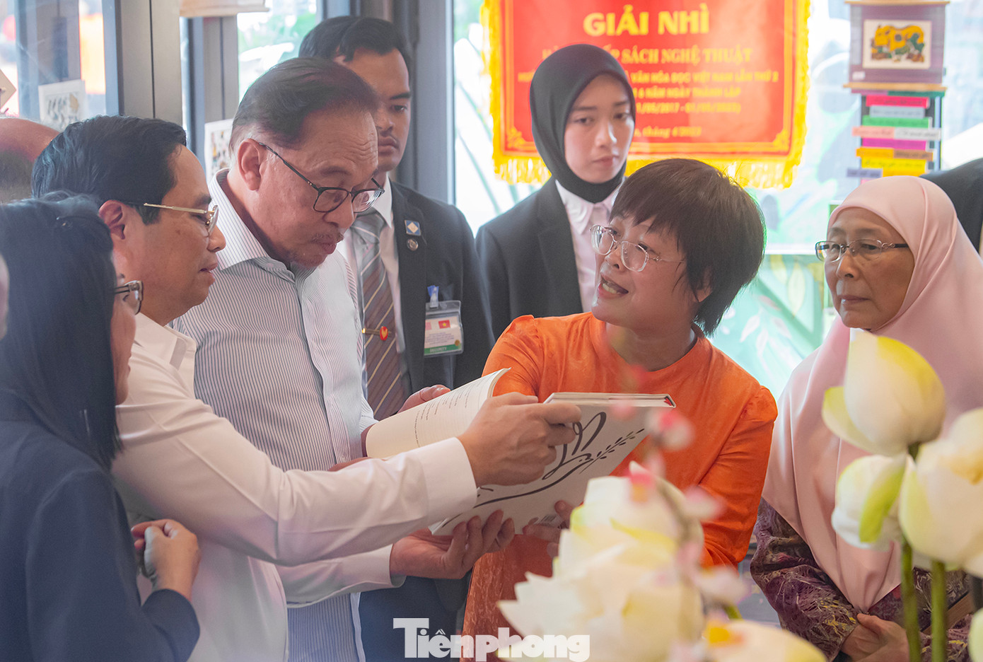 Hai Thủ tướng cùng hai Phu nhân nghe giới thiệu về sách. (Ảnh: Thái Nam)