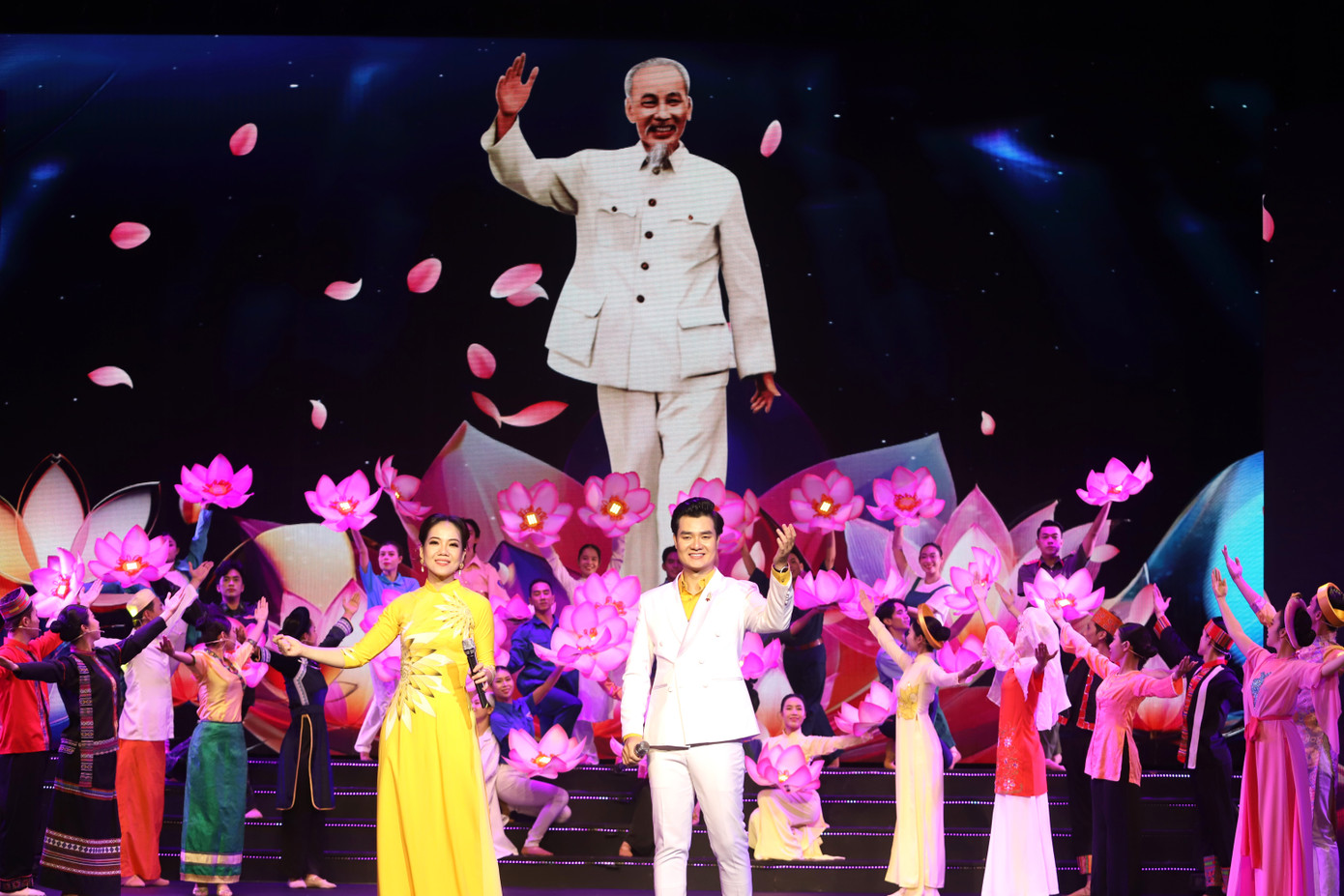 Đêm nghệ thuật diễn ra qua 3 phần, gồm Dâng Người ngàn hoa chiến công, Bài ca đại đoàn kết, Vinh quang Mặt trận Tổ quốc ta, với sự tham gia của các văn nghệ sĩ như NSND Tạ Minh Tâm, Hữu Quốc, Quế Trân, NSND Út Tỵ, NSƯT Vân Khánh, Văn Môn, Hạnh Thúy, các giọng ca trẻ Phạm Khánh Ngọc, Mai Thanh Sơn, Hồ Trung Dũng, Đào Mác… Trong ảnh là NSƯT Phạm Khánh Ngọc cùng Đào Mác kết hợp nhóm ca - múa biểu diễn ca khúc Dâng Người ngàn hoa chiến công. Đêm nghệ thuật diễn ra qua 3 phần, gồm Dâng Người ngàn hoa chiến công, Bài ca đại đoàn kết, Vinh quang Mặt trận Tổ quốc ta, với sự tham gia của các văn nghệ sĩ như NSND Tạ Minh Tâm, Hữu Quốc, Quế Trân, NSND Út Tỵ, NSƯT Vân Khánh, Văn Môn, Hạnh Thúy, các giọng ca trẻ Phạm Khánh Ngọc, Mai Thanh Sơn, Hồ Trung Dũng, Đào Mác… Trong ảnh là NSƯT Phạm Khánh Ngọc cùng Đào Mác kết hợp nhóm ca - múa biểu diễn ca khúc Dâng Người ngàn hoa chiến công.