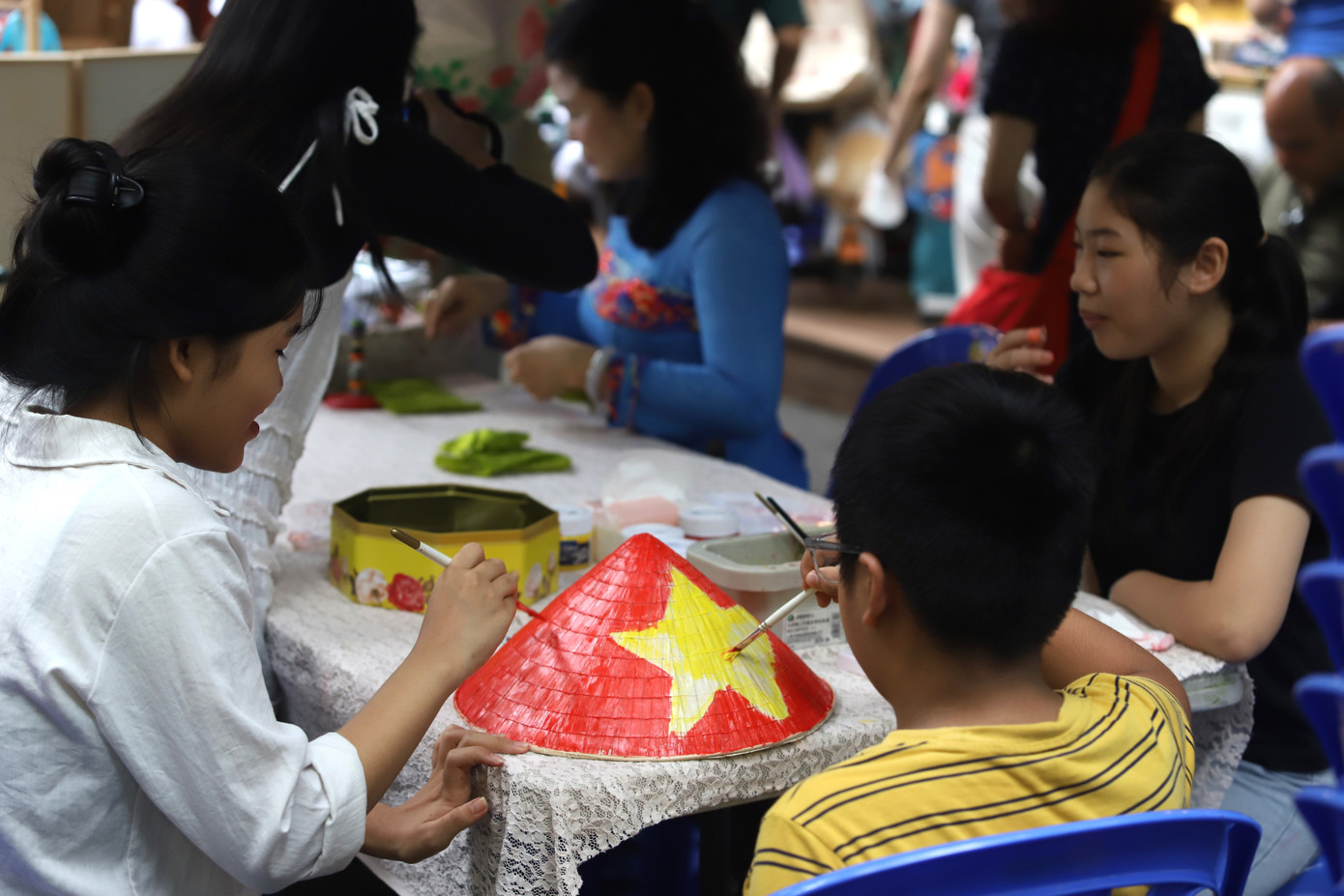 Đến đường sách vui chơi dịp lễ Quốc khánh, em bé vẽ hình cờ Tổ quốc lên nón lá. Đến đường sách vui chơi dịp lễ Quốc khánh, em bé vẽ hình cờ Tổ quốc lên nón lá.