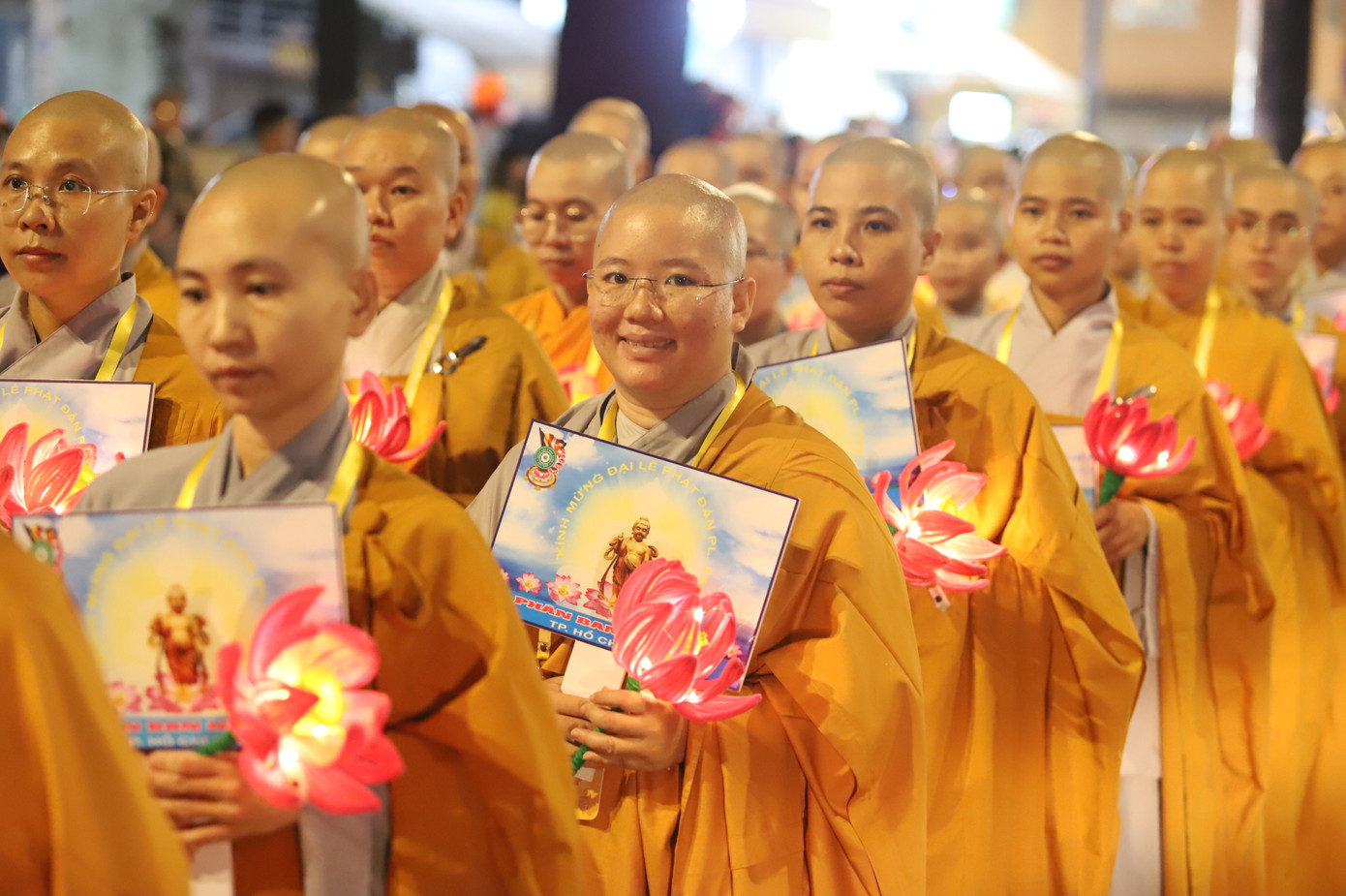 Các vị ni sư Phân ban ni giới TPHCM mang hình ảnh Đức Phật đản sinh cùng đóa sen hồng trong buổi rước lễ, diễu hành.