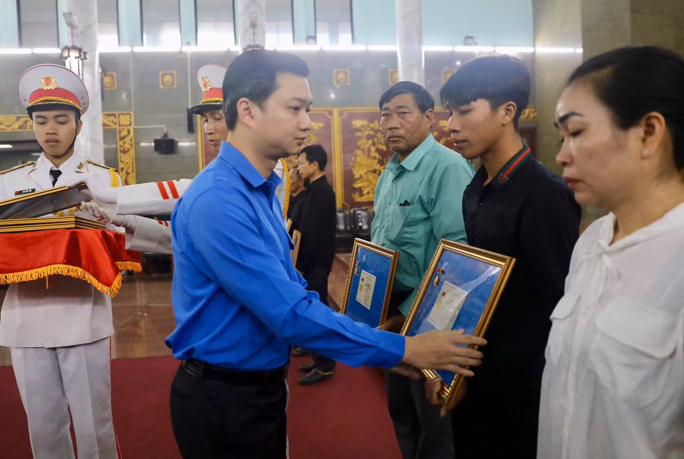 Anh Nguyễn Minh Triết - Bí thư Trung ương Đoàn, Chủ tịch Trung ương Hội Sinh viên Việt Nam trao Huy hiệu Tuổi trẻ dũng cảm đến thân nhân các liệt sĩ. Ảnh: Duy Anh