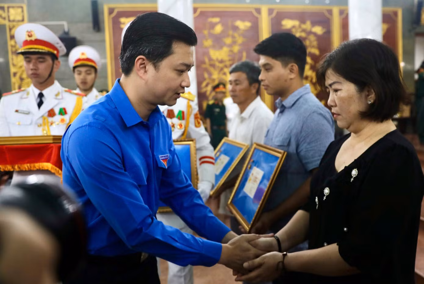 Anh Nguyễn Minh Triết - Bí thư Trung ương Đoàn, Chủ tịch Trung ương Hội Sinh viên Việt Nam trao Huy hiệu Tuổi trẻ dũng cảm đến thân nhân các liệt sĩ. Ảnh: Duy Anh