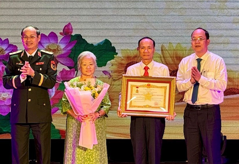 Phó Bí thư Thường trực Thành ủy TPHCM Nguyễn Hồ Hải cùng Tư lệnh Bộ Tư lệnh TPHCM Nguyễn Văn Nam trao danh hiệu Anh hùng Lực lượng vũ trang nhân dân cho thân nhân liệt sĩ Lê Thị Bạch Cát. Ảnh: Long Hồ