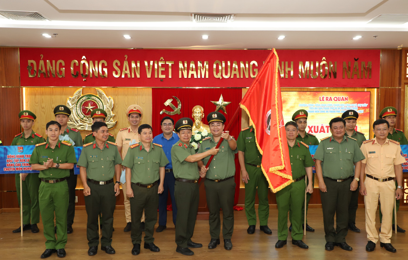 Phó giám đốc CATP Trần Đức Tài trao cờ xuất quân triển khai các hoạt động đồng hành cùng thanh niên công an xã, thị trấn.
