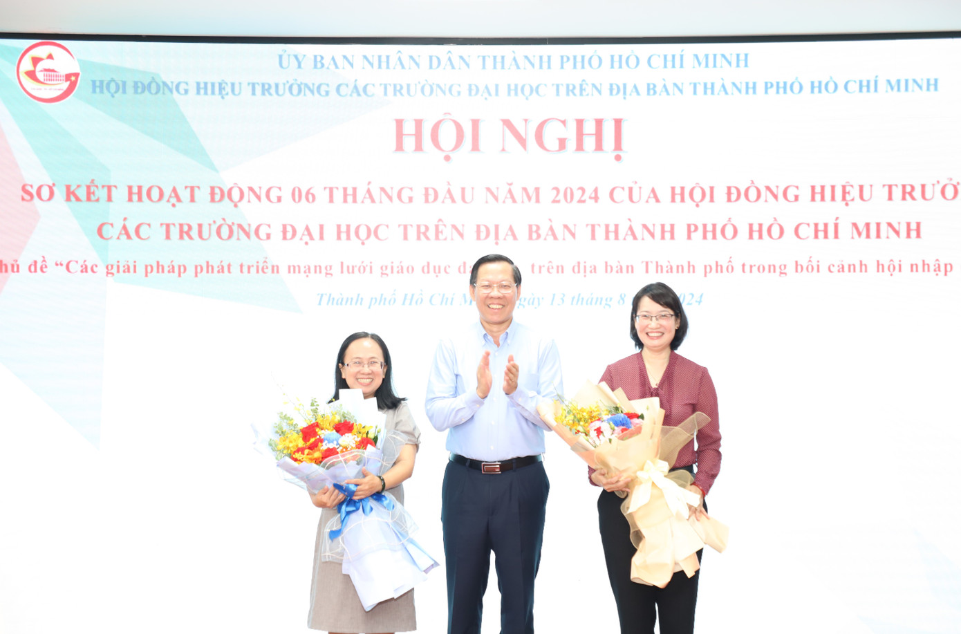 Chủ tịch UBND TPHCM Phan Văn Mãi trao hoa chúc mừng bà Trần Thị Diệu Thúy (phải) và bà Đinh Thị Thanh Thủy. Ảnh: Ngô Tùng
