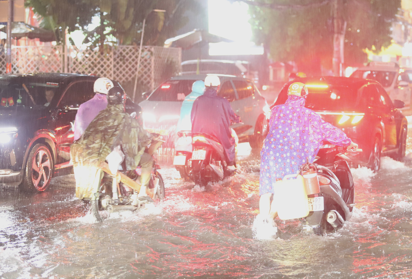 Sau ít phút chờ, người thân đến hỗ trợ người phụ nữ dắt xe ra khỏi đoạn ngập.