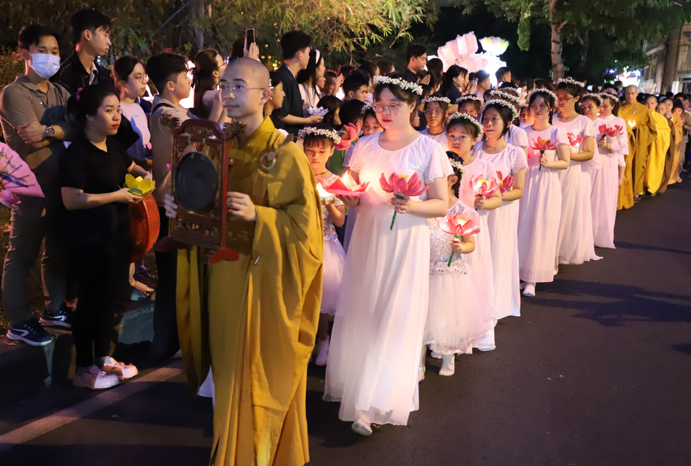 Sau khóa lễ cầu kinh, đoàn rước lễ di chuyển đến khu vực gần mép nước để bắt đầu nhận và thả hoa đăng của bà con Phật tử, người dân.