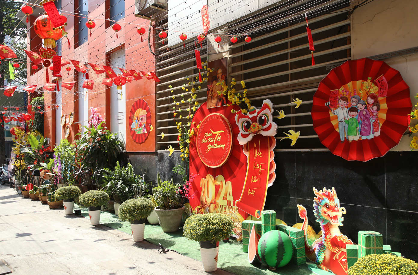 Suốt chiều dài khoảng 100m của tuyến hẻm này được trang hoàng, sắp đặt đầy đủ các loại hoa xuân cùng những tiểu cảnh chào đón Tết. Linh vật rồng của năm Giáp Thìn 2024 cũng "góp mặt" ở không gian này, bên cạnh hình ảnh ông lân, lồng đèn... quen thuộc trong đời sống văn hóa Việt.