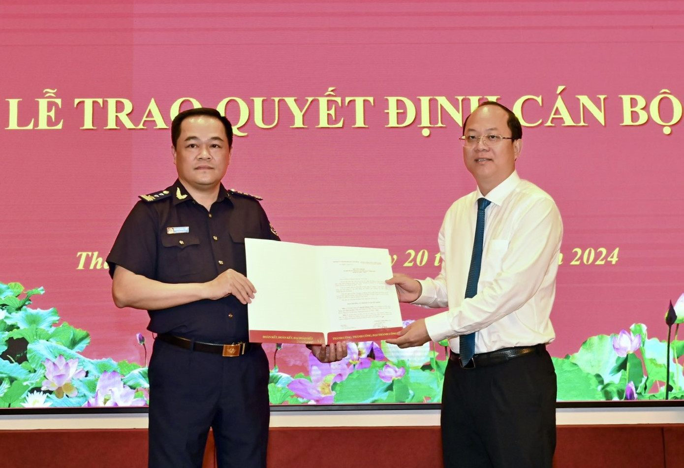 Phó Bí thư Thường trực Thành ủy TPHCM Nguyễn Hồ Hải (bên phải) trao quyết định cho ông Nguyễn Hoàng Tuấn (Ảnh: Việt Dũng)