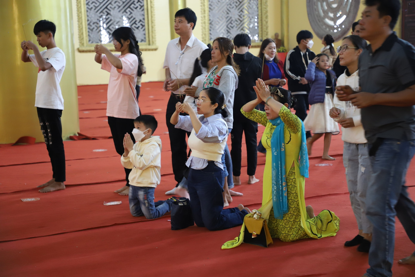 Người lớn, em nhỏ thành kính thắp hương lễ Phật ngày Tết.