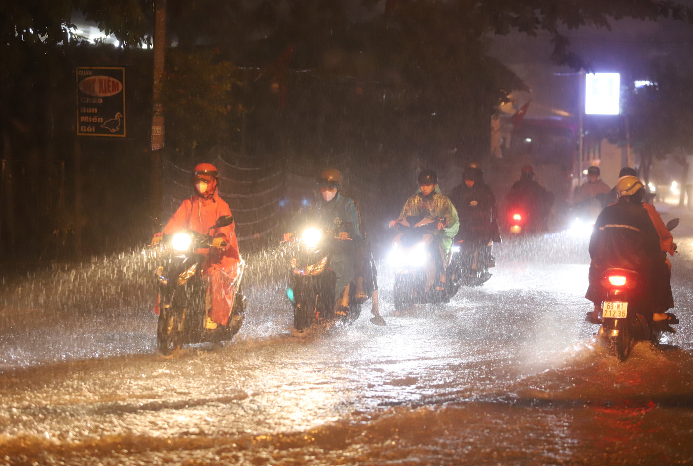 Các phương tiện di chuyển chậm qua một đoạn bị ngập trên tuyến đường Đình Phong Phú.