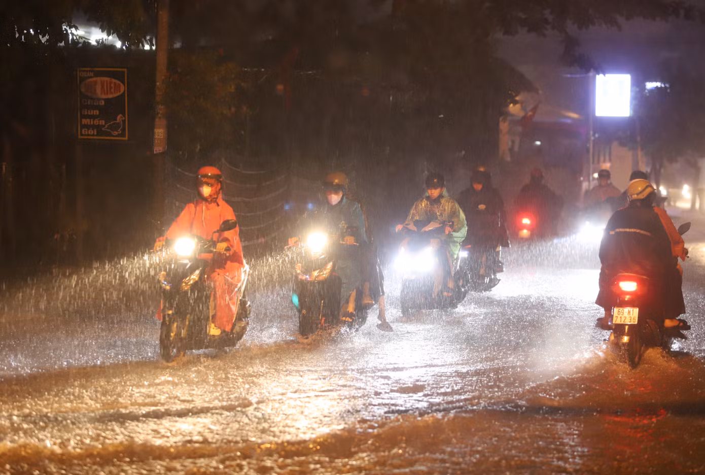 Các phương tiện di chuyển chậm qua một đoạn bị ngập trên tuyến đường Đình Phong Phú.