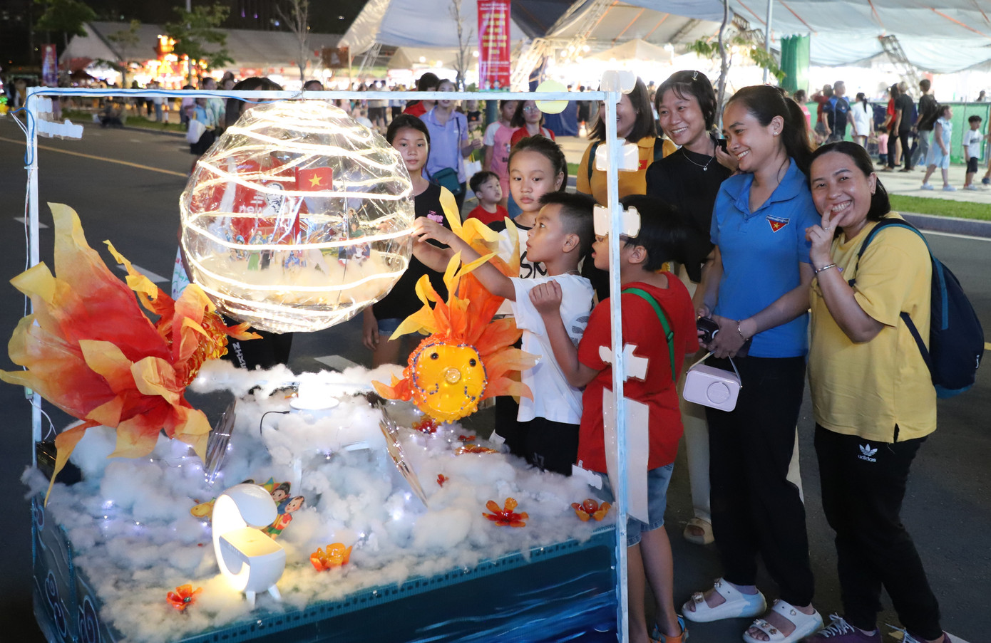 Các em ngắm nhìn chiếc xe đèn lồng với tạo hình các chú cá rực rỡ sắc màu. Ảnh: Ngô Tùng Các em ngắm nhìn chiếc xe đèn lồng với tạo hình các chú cá rực rỡ sắc màu. Ảnh: Ngô Tùng