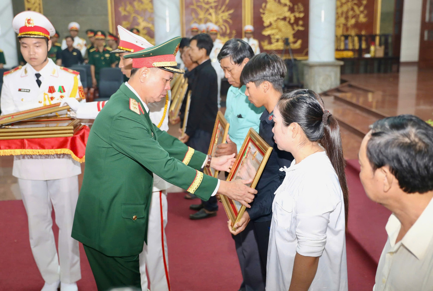 Trung tướng Nguyễn Trường Thắng, Tư lệnh Quân khu 7 trao Huân chương Bảo vệ Tổ quốc hạng Ba cho thân nhân các liệt sĩ. Ảnh: Duy Anh