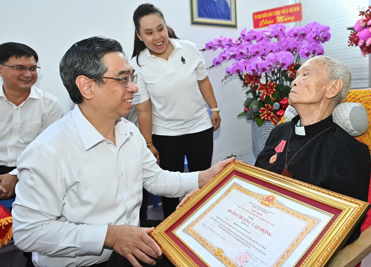 Phó Bí thư Thành ủy, Chủ tịch Ủy ban MTTQ Việt Nam TPHCM Nguyễn Phước Lộc trao Huân chương Lao động hạng Ba của Chủ tịch nước tặng Linh mục Phan Khắc Từ. Ảnh: MTTQ