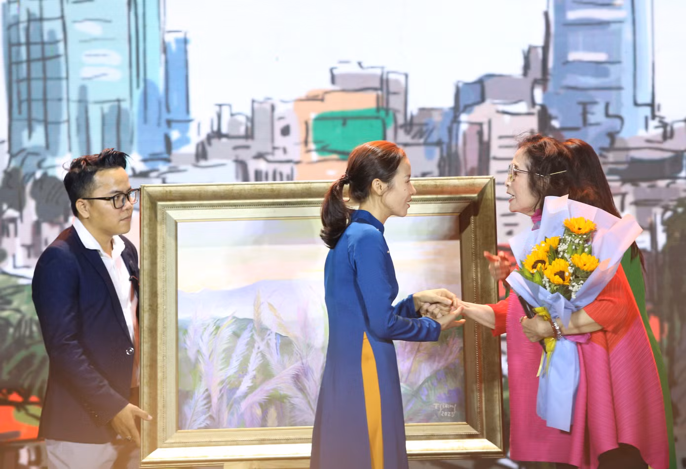 Minh tinh điện ảnh Việt trò chuyện, trao hoa cảm ơn đại diện người tham gia đấu giá bức tranh của mình.