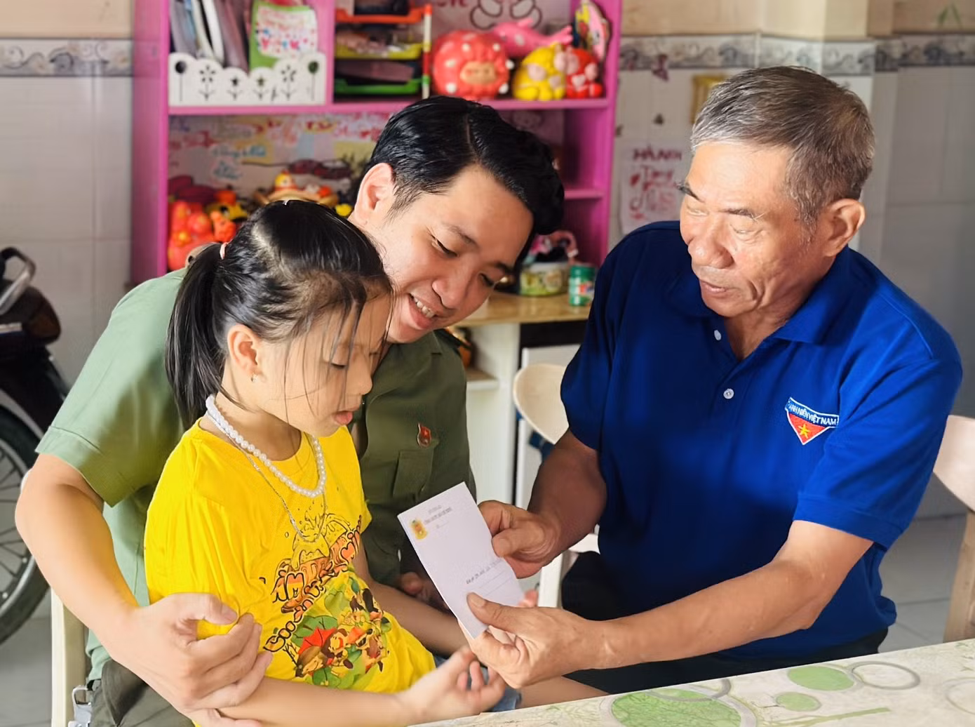 Thượng úy Phan Đình Linh (bên trái) cùng đại diện Ban Liên lạc Câu lạc bộ Cựu cán bộ Đoàn CATP đến thăm, tặng quà các em nhỏ con nhân dịp Quốc tế Thiếu nhi. Ảnh: CATP
