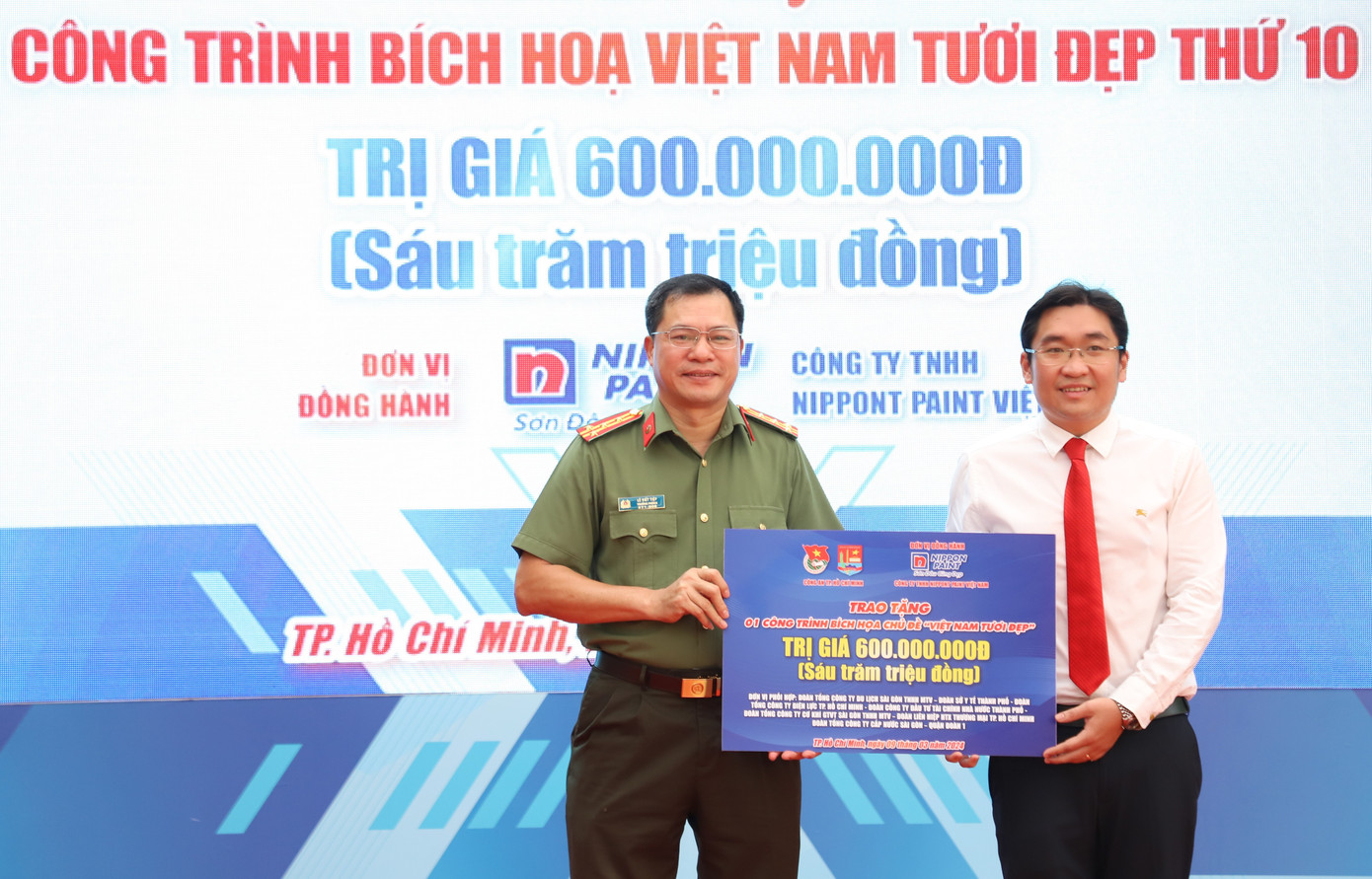 Đại diện lãnh đạo Công an TPHCM trao tặng công trình bích họa cho Đảng ủy, UBND phường Cầu Ông Lãnh. Ảnh: Ngô Tùng
